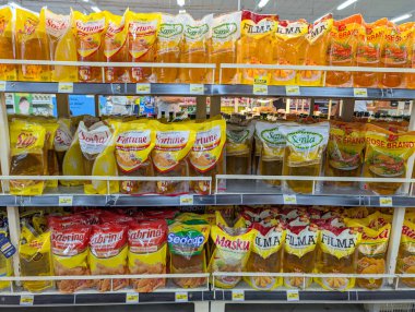 Denpasar, Bali. 22 Aralık 2025. Çeşitli markalardaki parlak sarı yağlar Denpasar 'daki bir süpermarketin raflarında sıralanır..