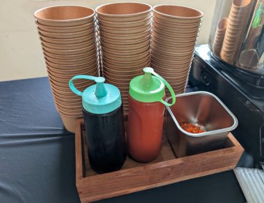 Organize yiyecek ve içecek servis ekipmanları, kullanışlı baharat şişeleri ve tek kullanımlık bardaklarla birlikte..