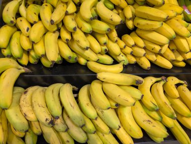 Sarı muzlar istiflenir ve bir meyve dükkanında sergilenir..