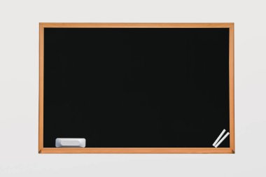 Sehpada tebeşir ve silgiyle izole edilmiş arkaplanda kara tahta