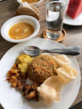 Lezzetli bir tabak Nasi Goreng Endonezya usulü kızarmış pilav çıtır kerupuk baharatlı patates sambal tavuğu ve lezzetli bir yemek için baharatlı meze..