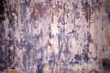 Aşırı yıpranmış ve çatlamış yüzey yüzeyinin soyut arkaplanı dikey soyulmuş boya damlalarını ve sıkıntılı kahverengi ve mor tonların örtüler ve grafik tasarımı için uygun olduğunu gösteriyor.