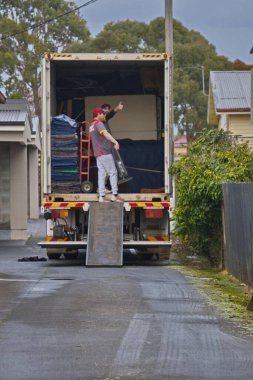 Devonport, Tazmanya. Aust. 22 07 2025. İki genç işçi taşınmak için ev mobilyalarını nakliye kamyonuna yüklüyorlar..                                      