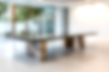 Geniş pencerelerle çevrili bulanık bir konferans masasını gösteren şık ve modern bir ofis, davetkar ve üretken bir çalışma alanı yaratıyor..