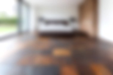 Bu resim, ahşap döşeme, büyük pencereler ve minimalist bir dizaynın yer aldığı modern bir iç mekan sergiliyor, sakin ve davetkar bir atmosfer yaratıyor..