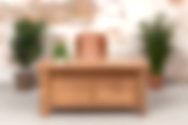 Bu resim, verimli yeşil bitkilerle çevrili çağdaş bir ofis alanında, üretkenlik için sıcak ve davetkar bir atmosfer yaratan modern bir ahşap masa sergiliyor..