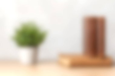 Tahta bir kitabın yanında yeşil bir saksının içinde, minimalist dekor için mükemmel sıcak bir atmosfer yaratan sıcak ve davetkar bir sahne..