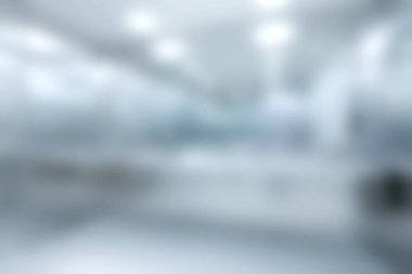 Bu resim, çalışma alanı estetiği projeleri için ideal parlak ışıklandırma ve parlak tasarım unsurlarının vurgulandığı, modern bir ofis içinin bulanık bir görünümünü sergiliyor..