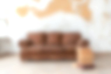 Oturma odası sahnesinde kahverengi bir kanepe, sanatsal dokulu bir duvarla tamamlanmış, rahat ve şık bir ev dekorunun özünü yakalıyor..