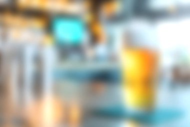 Tezgahta canlandırıcı bir içecek tasvir eden canlı bir sahne. Parlak bir bar ortamı sergiliyor. Bulanık arka plan canlı ve davetkar bir atmosfer ekler..