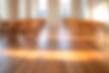 Bu görüntü, parlayan ahşap zemini ve alanı aydınlatan yumuşak güneş ışığıyla birlikte parlak bir iç mekan gösteriyor. Minimalist tasarım sıcak ve davetkar bir atmosfer yaratır..