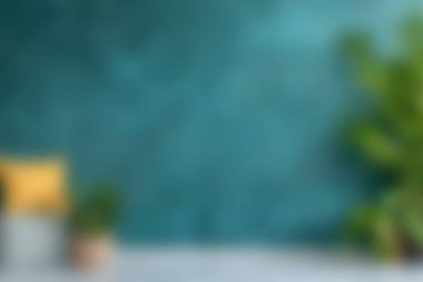 İçinde dokulu yeşil bir duvar, saksı bitkileri ve neşeli sarı bir yastık olan rahat bir iç mekan. Yaşayan her yer için taze ve davetkar bir ortam yaratıyor..