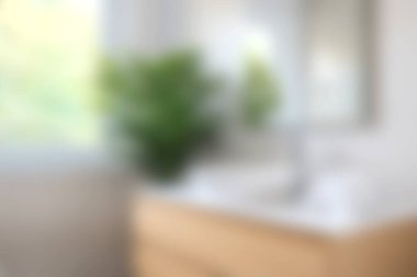 Minimalist tasarımı, parlak güneş ışığı ve dinginlik ve ilham için sakin bir atmosfer yaratan yemyeşil bir banyo..