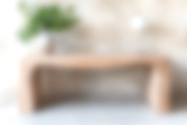 Bu resim, tarafsız bir zemin üzerine kurulmuş yemyeşil bir bitkiye sahip modern bir ahşap masa içeriyor. Minimalist tasarım ve çağdaş estetiği somutlaştırır..