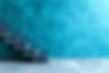 Bu resim, modern bir iç mekan, cesur mavi bir duvar ve parlak siyah bir merdiven içeriyor, çeşitli tasarım projeleri için uygun şık ve sakin bir atmosfer yaratıyor..