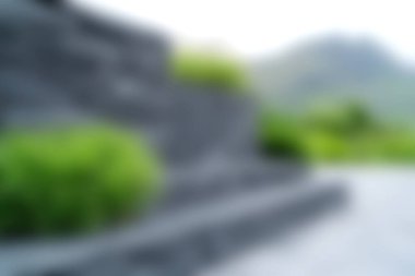 Berrak, bulanık manzaralı, yemyeşil ve uzak dağ zirveleri olan dokulu taş bir duvar. Huzurlu manzara temaları için mükemmel.