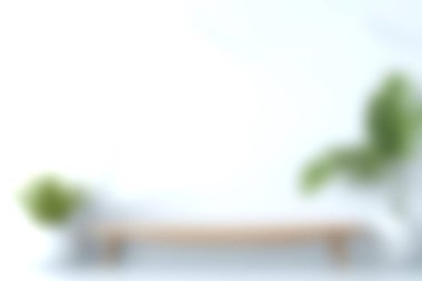 Minimalist bir iç mekanın, ahşap bir bank ve bereketli bir iç mekan bitkisinin yumuşak bulanık görüntüsü modern ev dekorasyonu için mükemmel ve davetkar bir atmosfer yaratıyor..