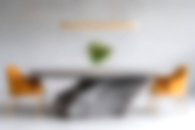 Bu modern minimalist oturma odasında şık mobilyalar, sarı sandalyeler ve canlı bir dokunuş için kapalı bir bitki tarafından tamamlanmış gri bir kanepe bulunuyor..