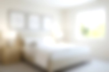 Bu resim, sakin bir atmosferi, rahat mobilyaları, parlak doğal ışığı ve barışçıl bir geri çekilme için minimalist tasarım unsurları olan yumuşak ışıklı bir yatak odasını yakalıyor..