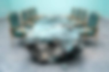 Turkuaz dekorlu şık sandalyelerle çevrili yuvarlak bir masanın yer aldığı çağdaş bir konferans odası, toplantı ve işbirliği için ideal..