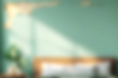 Sakin yeşil duvarlarda çalan yumuşak doğal ışığın yer aldığı sakin bir yatak odası sahnesi, minimalist dekorlar ve rahatlamak için mükemmel rahat bir atmosfer..