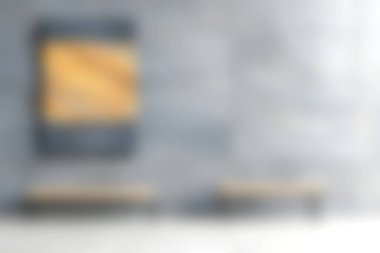 Bu resim modern minimalist bir sanat sergisi sergiliyor, dokulu bir duvara karşı banklar sergileniyor, sanatın takdir edilmesi için sakin ve davetkar bir atmosfer yaratıyor..