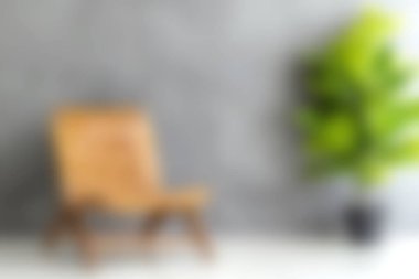 Ahşap bir sandalye ve yemyeşil bir bitkinin yer aldığı sakin ve minimalist bir iç mekan, desenli gri bir duvara dayalı, ev dekorasyonu projeleri için mükemmel..