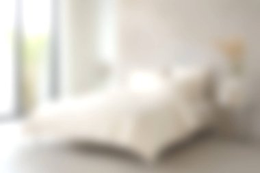 Bu resimde minimalist bir tasarımı olan rahat bir yatak odası var. Yumuşak ışıklandırma, açık renk düzenini ve zarif mobilyaları vurgulayan sakin bir atmosfer yaratır..