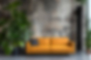 Zarif ve davetkar bir oturma odası. Parlak sarı bir kanepe, yemyeşil bitkilerle çevrili. Rahatlamak için mükemmel sıcak ve modern bir atmosfer yaratıyor..