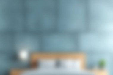 Sakin bir yatak odası görüntüsü. Mavi bir duvar ve rahat bir yatak. Rahatlamak ve rahatlamak için mükemmel bir ortam yaratıyor..