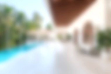 Berrak mavi su, yemyeşil ve rahatlama ve keyif için mükemmel davetkar bir atmosferi olan çarpıcı bir modern havuz kenarı..