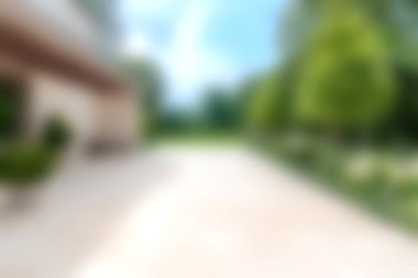 Yumuşak gün ışığında yıkanmış yemyeşil bir bahçenin olduğu bulanık bir açık hava sahnesi. Bu resim rahatlama temaları için ideal olan dinginlik ve sükuneti iletir.