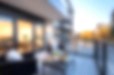 Canlı bir günbatımı gökyüzüne bakan şık mobilyaların yer aldığı sakin, modern bir balkon sahnesi. Rahatlama ve şehir sükunetini yakalamak için mükemmel..