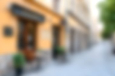 Renkli dükkanlar ve yemyeşil çiçeklerle dolu büyüleyici bir cadde manzarası tarihi bir Avrupa şehrinde huzurlu bir atmosfer sergiliyor..