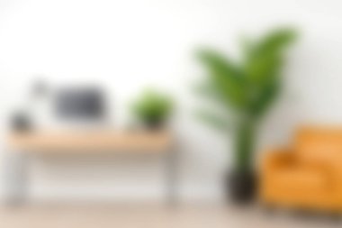 İçinde bilgisayar, rahat sarı sandalye ve canlı yeşil bitki barındıran modern bir masa barındıran parlak ve davetkâr bir ofis. Çalışma ve ilham için mükemmel..