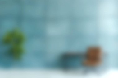 Yumuşak mavi bir duvar, ahşap bir sandalye ve her ayrıntıda zarafet ve rahatlığı birleştiren yemyeşil bir bitki içeren sakin bir minimalist iç mekan keşfedin..