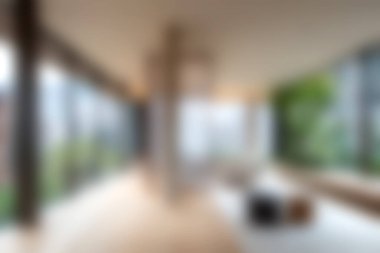 Bu resim doğal ışık, büyük pencereler ve yeşilliklerle dolu modern bir minimalist yaşam alanını gösteriyor. Rahatlamak için mükemmel bir ortam yaratıyor..