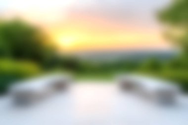 Bulanık manzaralı sakin bir avlu yemyeşil bir manzaranın üzerinde çarpıcı bir günbatımı sunuyor, huzur ve sükuneti çağrıştırıyor. Rahatlamak için mükemmel..