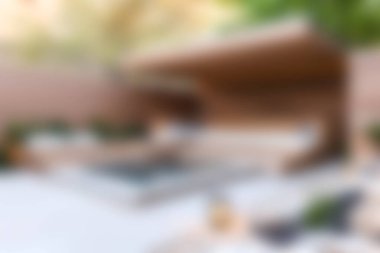 Bu resim, yeşil alanlarla çevrili, rahatlama ve rahatlama için mükemmel sakin bir dinlenme alanı içeren modern bir açık havuz tasarımı sergiliyor..