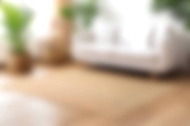 Dinlendirici bir oturma odası sahnesi. Canlı yeşil bitkilerle çevrili beyaz bir kanepe. Huzurlu ve davetkar bir atmosfer sunuyor..