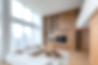 Bu resim, şık mobilyaların ve doğal ışığın bol olduğu rahat ve modern bir oturma odasını gösteriyor. Sıcak ahşap aksanlar davetkar atmosferi güçlendirir..