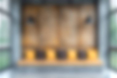 Yumuşak bulanık bir görüntü, rahat koltuklar, sıcak ahşap paneller ve bol doğal ışık ile modern bir iç mekan sergiliyor, rahatlama için ideal sakin bir atmosfer yaratıyor..