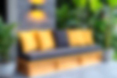 Yumuşak yastıkların ve yemyeşil yeşilliğin bulunduğu rahat bir açık hava oturma alanı keşfedin, sakin bir ortamda rahatlama ve rahatlama için mükemmeldir..