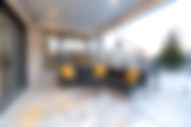 Bu resim, güneşli bir terasta rahatlamak için mükemmel dekoratif yastıklı şık oturma yerleri olan modern bir açık hava salonu sergiliyor..