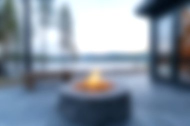 Sıcak, açık bir ateş çukuru, alacakaranlıkta sakin bir gölün kıyısında, doğa güzelliğinin ortasında toplanmak için sıcak ve dingin bir atmosfer sunar..