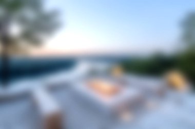 Relaxing outdoor lounge area features a serene pool with a stunning sunset view, perfect for leisure. Enjoy tranquil moments and beautiful scenery.