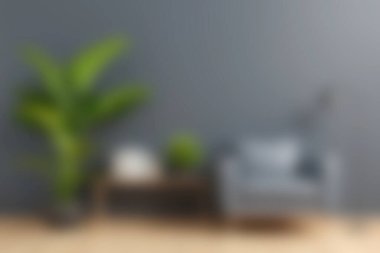 Rahat gri bir sandalye, dekoratif bitkiler ve minimalist bir tasarımın yer aldığı şık bir oturma odası sahnesi rahatlama ve ilham için huzurlu bir atmosfer yaratıyor..