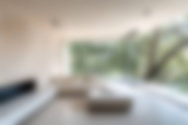 Doğanın huzurlu manzarasını sunan geniş pencereli şık, modern bir oturma odası. Minimalist tasarım rahatlık ve sükuneti vurgular..