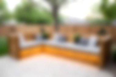 Açık havada rahat bir oturma düzeneği. Yastıklar ve bitkiler, güneşli bir bahçede rahatlamak ve rahatlamak için mükemmel..