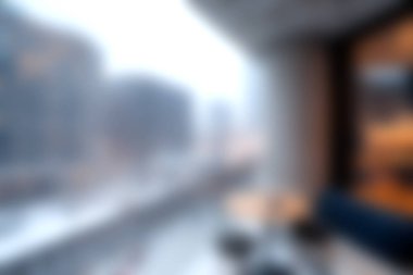 Kışın bulanık bir şehir manzarasının pencereye yansıtıldığı rahat bir iç mekan, dinlenmek için mükemmel bir ortam yaratıyor..